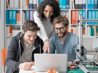 Group of students using a 3D printer and a laptop - Powered by Adobe