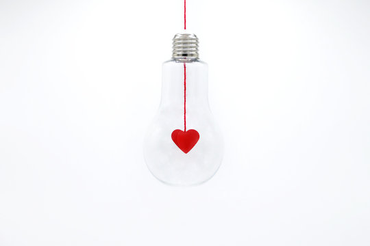 3D real paper cut of red heart shaped inside the light bulb.The light of love.Minimal concept.Copy space for text.Easy to use for card decoration