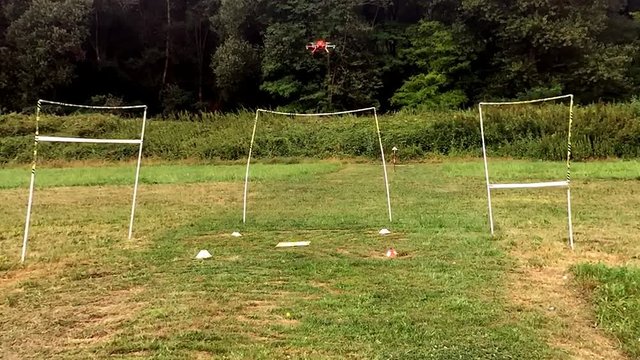Hexacopter in training flying through obstacles at low altitude over the lawn.