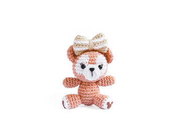 Crochet doll. Amigurumi or Crochet doll of a cute teddy bear with big ribbon bow isolated on a white background