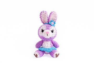 Crochet doll. Amigurumi or Crochet doll of a cute Easter bunny with a blue flower on her ears isolated on a white background