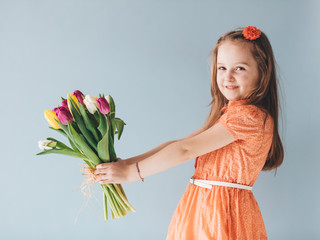 Girl holding a bunch of colorful tulips.