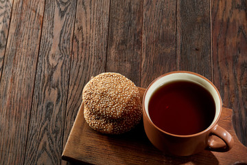 Cup of tea with cookies, workbook and a pencil on a wooden background, top view