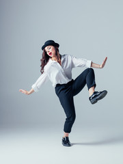 Young beautiful female dancer is posing in the studio