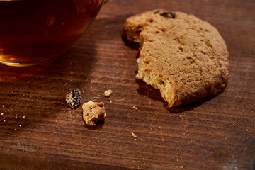 Cup of tea with cookies on a cutting board on a wooden background, top view