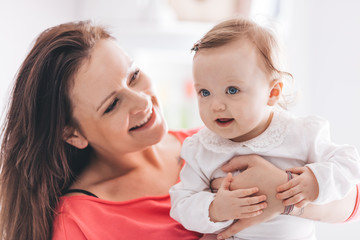 Happy mother holding her baby daughter