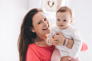 Young mother hugging her baby daughter