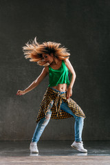 Young beautiful female dancer is posing in the studio