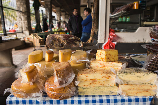 The farm food market. A lot of cheeses on the sales counter.