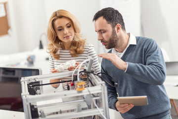 Best explanation. Charming bristled engineer explaining to his female colleague how to use a 3D...