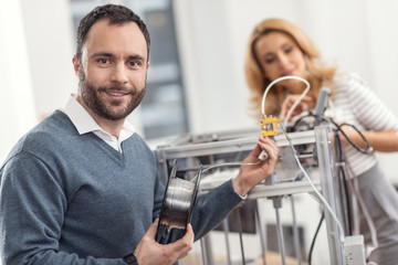 Great skills. The focus being on a pleasant handsome young man posing for the camera while replacing the filament in the 3D printer