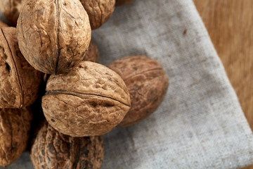 A stack of walnuts piled together and on rustic wooden background, shallow depth of field, selective focus