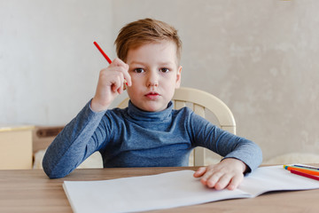 the boy draws at the table