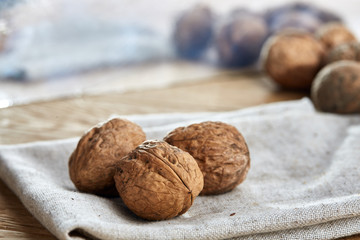 A stack of walnuts piled together and on rustic wooden background, shallow depth of field, selective focus