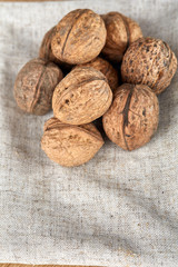 A stack of walnuts piled together and on rustic wooden background, shallow depth of field, selective focus