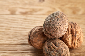 A stack of walnuts piled together and on rustic wooden background, shallow depth of field, selective focus