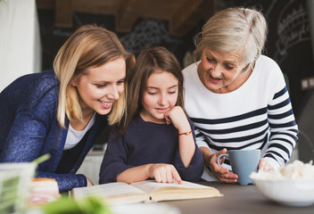 A small girl with mother and grandmother at home.