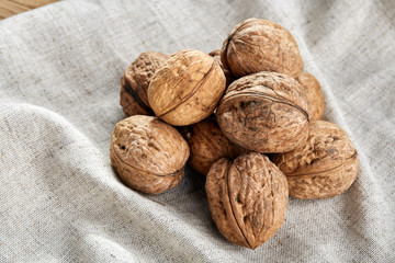 A stack of walnuts piled together and on rustic wooden background, shallow depth of field, selective focus