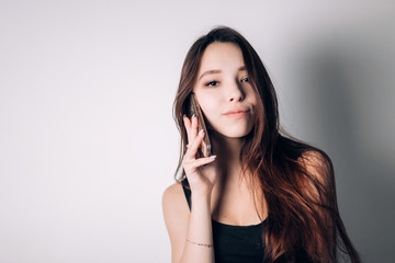 Fototapeta premium Girl calling on phone. Beautiful woman uses a smartphone