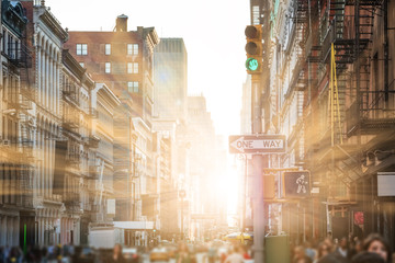 Sunlight shines on people walking the streets of SoHo in New York City