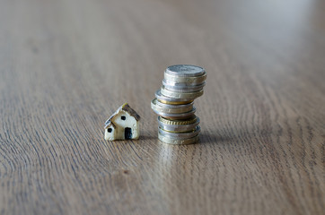 Real estate mortgage concept with small plastic house and coins