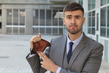 Fototapeta premium Perplexed businessman holding his empty wallet