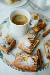 Coffee mug with apple cinnamon cake pieces on white background