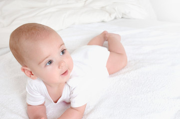 Happy laughing baby relax on bed.