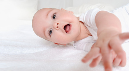 Happy laughing baby relax on bed