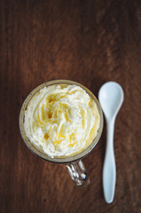 Coffee mug with homemade pumpkin spice syrup and whipped cream toping. Wooden background, top view.