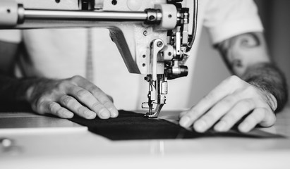 Close-up man hands sewing fabric on sewing machine