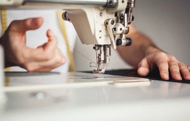A sewer threading a needle in the sewing machine.