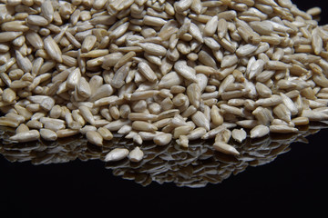 Sunflower peeled seeds on a black background.