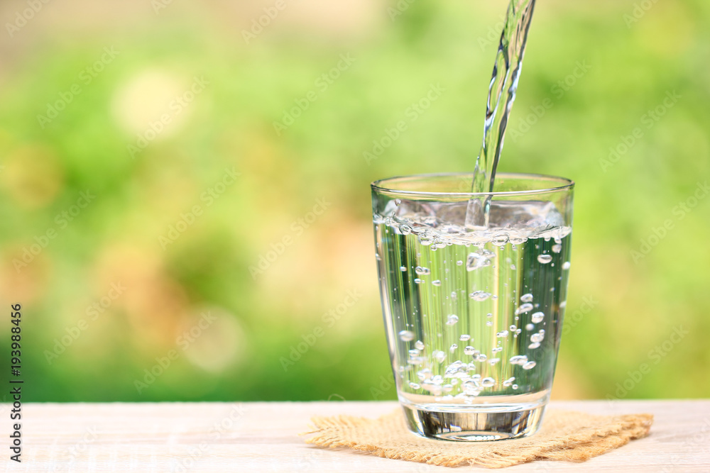 Wall mural closeup glass of water on table nature background