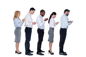 Obraz premium Staying in touch. Attractive addicted stylish young colleagues standing behind each other and holding their phones and typing on them
