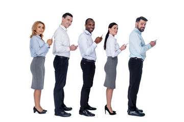 Fototapeta premium Communication. Good-looking inspired stylish young colleagues standing behind each other and holding their phones and smiling