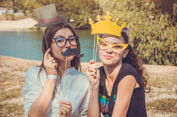 Two young women posing using photo booth props