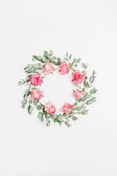 Floral frame wreath made of red rose flowers and eucalyptus branches isolated on white background. Flat lay, top view bridal mockup.