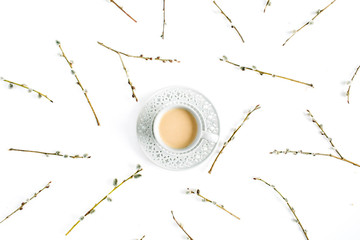 Cup of coffee with milk and willow branches pattern on white background. Flat lay, top view.