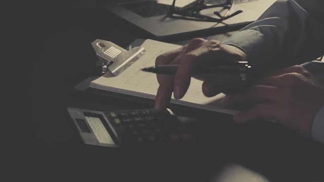 businessman hand working with finances about cost and calculator and laptop with mobile phone on withe desk in modern office
