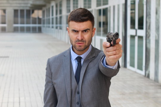 Elegant angry man holding gun