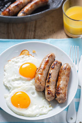Fried eggs with sausages and orange juice