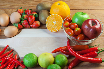 Healthy concept with mixed fruits and vegetables on wooden background