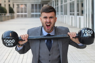 Funny businessman lifting heavy weights