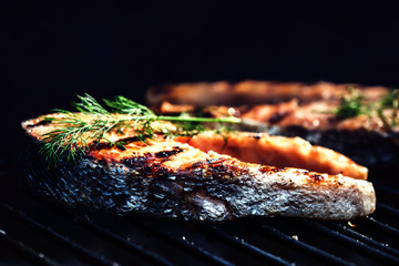 Salmon steaks cooking on barbecue grill. Food background with barbecue party