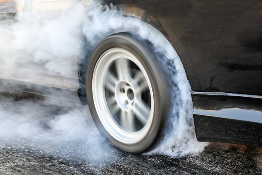 Drag racing car burns rubber off its tires in preparation for the race © toa555