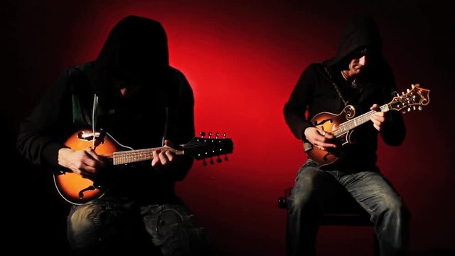 2 Mysterious Hooded Musicians Playing Mandolin in the Shadows 2