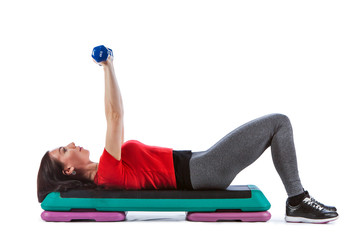 Fitness woman is exercising with the dumbs and stepper.