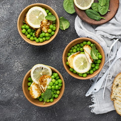 Green young peas, cheese haloumi, lemon. orange salad with slices of bread. Top View