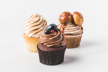 close up view of various sweet cupcakes isolated on white